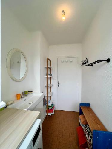 une salle de bain avec un lavabo et un miroir dans l'établissement Détente fleurie tout près du sentier côtier, à Concarneau