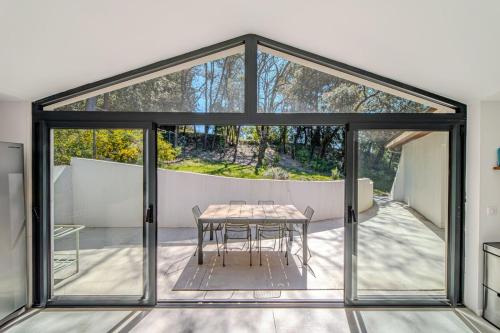 une extension en verre d'une maison avec une table et des chaises dans l'établissement Villa Valeze - Bali pool with Pic-Saint-Loup view, à Prades-le-Lez
