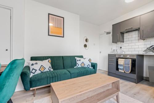 a living room with a green couch and a table at Cedar View - 2 Bed Apartment in Newport