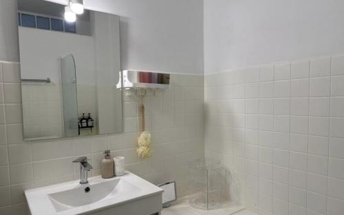 a white bathroom with a sink and a mirror at L’Évasion tropicale à cannes (wifi - Netflix) in Le Cannet