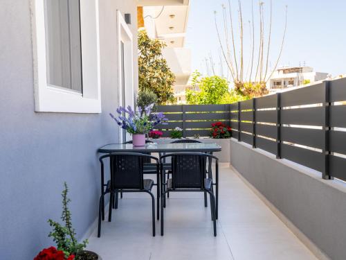 a table and chairs on a balcony with flowers at Natalia's Nest in Ampavris