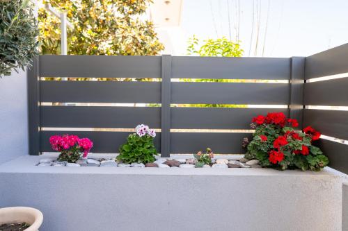 a garden with flowers on a retaining wall at Natalia's Nest in Ampavris