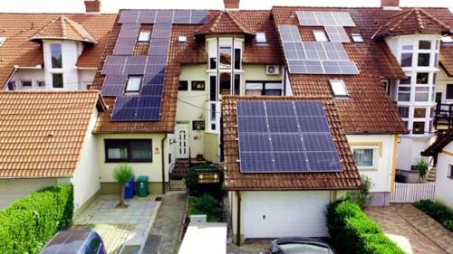 a row of houses with solar panels on their roofs at Era Apartman in Harkány