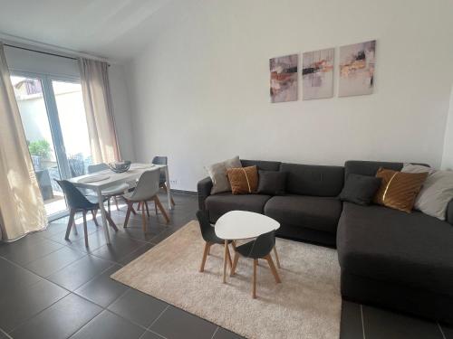 un salon avec un canapé noir et une table dans l'établissement Appartement Cannes 3P, terrasse, garage, à Cannes