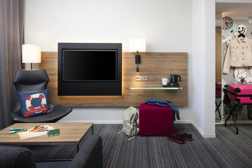 a living room with a flat screen tv in a hotel room at Moxy Southampton in Southampton