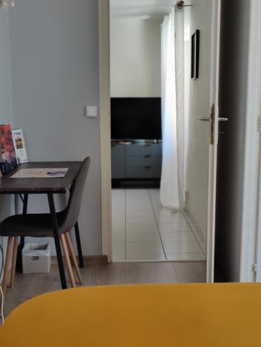 un salon avec une table et une porte avec une télévision dans l'établissement Chez Cédric, à Annecy