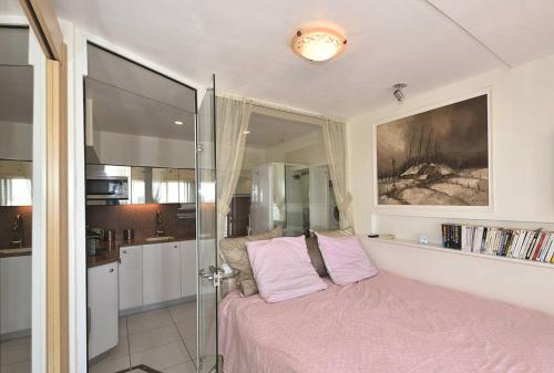 - une chambre avec un lit rose et une douche en verre dans l'établissement Appartement NAUTIC - Port Nature PN583 - 2 personnes, au Cap d'Agde