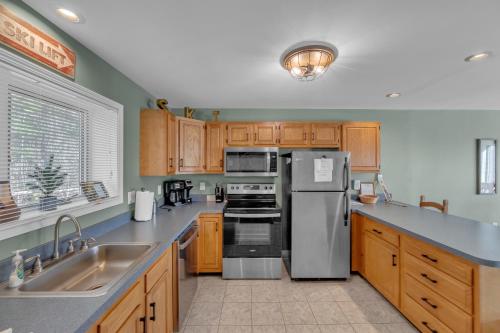 une cuisine avec des appareils en acier inoxydable et des armoires en bois dans l'établissement 18N - Cozy & Scenic Mountain Retreat, à North Creek