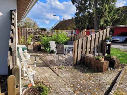 a garden with a fence and a table and chairs at geraümige Wohnung im Grünen in Vollrathsruhe