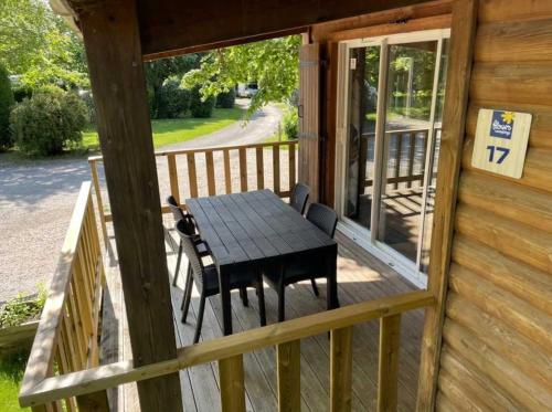 - une table et des chaises sur la terrasse couverte d'une cabine dans l'établissement Chalet 3 étoiles - ccaaafc, à Sorèze
