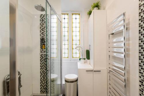 une salle de bain avec une douche en verre et des toilettes dans l'établissement Chic Parisian Stay Trocadéro & Eiffel Tower, à Paris
