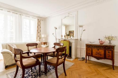 un salon avec une table et des chaises dans l'établissement Chic Parisian Stay Trocadéro & Eiffel Tower, à Paris