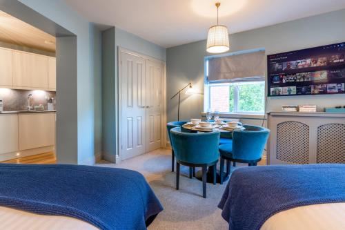 a dining room with a table and blue chairs at Silcox House Bath in Bath