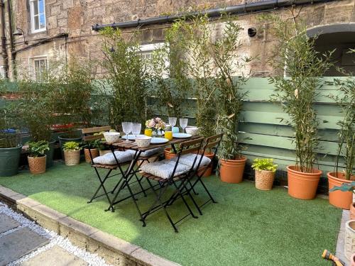 a table and chairs on grass with potted plants at The Broughton Townhouse in Edinburgh