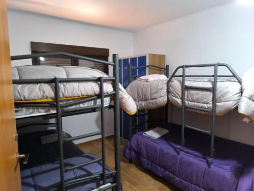 Habitación con 3 literas y 1 cama pequeña. en Casa Rural El Albergue, en Beires
