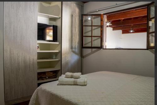 a bedroom with a bed with two towels on it at Chalé amanhecer in Santo Antônio do Pinhal