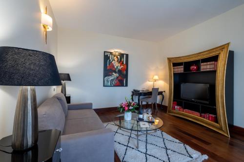 a living room with a couch and a television at Hôtel Demeure Loredana in Saint-Florent