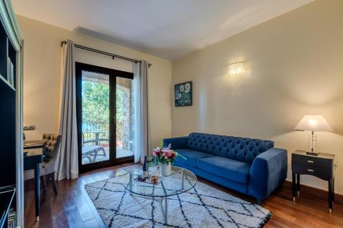 a living room with a blue couch and a glass table at Hôtel Demeure Loredana in Saint-Florent