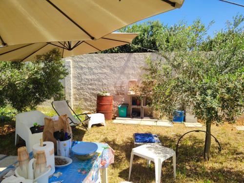 a table and chairs with an umbrella in a yard at Suite12 in Marsala