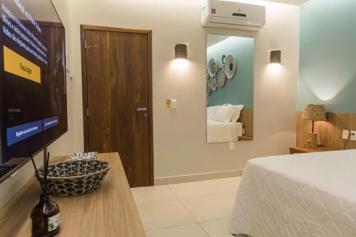 a room with a bed and a television and a bedroom at Manati in Barra Grande