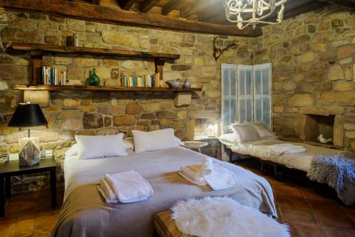 a bedroom with two beds and a stone wall at La Casa Del Manco in Villar