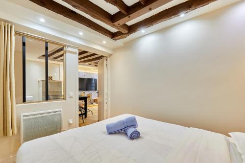 une chambre avec un lit avec une serviette bleue dessus dans l'établissement Rent a Room - Cosy 2BDR, à Paris