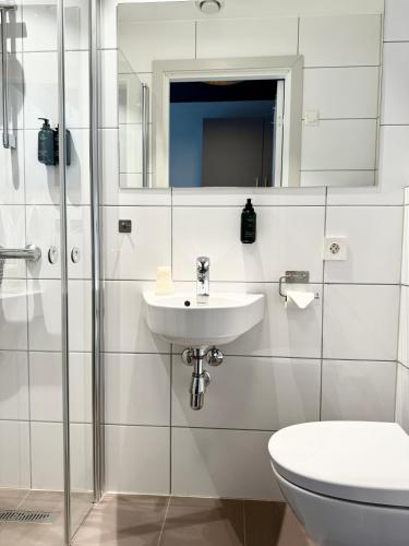 a white bathroom with a sink and a toilet at Wilhelmsen House in Tønsberg