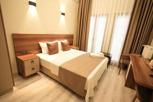 a hotel room with a bed with a phone on it at Kocabıçak Buca Hotel in Buca