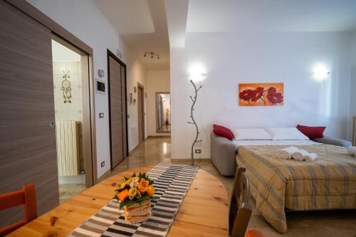Un dormitorio con una cama y una mesa con flores. en La casa di Nonna Petra, en Alberobello