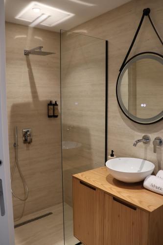 Un baño con lavabo y ducha con espejo. en Adriatic Stay, en Durrës