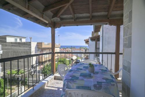 a table on a balcony with a view of the ocean at Alma House by RentalsPro - Nea Flogita Halkidiki in Flogita