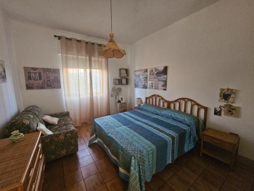 a bedroom with a bed and a couch at Casa Vacanze Nonna Nina in Casalabate