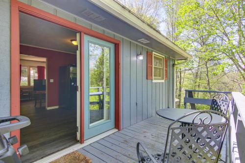 a porch with a table and a glass door at 1 Mi to Pisgah Natl Forest Wooded Haven with Deck in Pisgah Forest