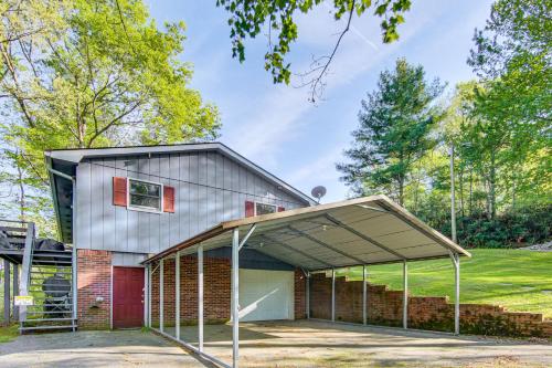 a house with a garage with a red door at 1 Mi to Pisgah Natl Forest Wooded Haven with Deck in Pisgah Forest