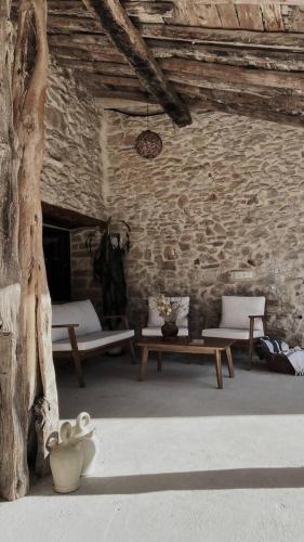 ein Zimmer mit 2 Bänken und einem Tisch in einer Steinmauer in der Unterkunft Casa Rural Acogedora en Veguillas de la Sierra in Veguillas de la Sierra