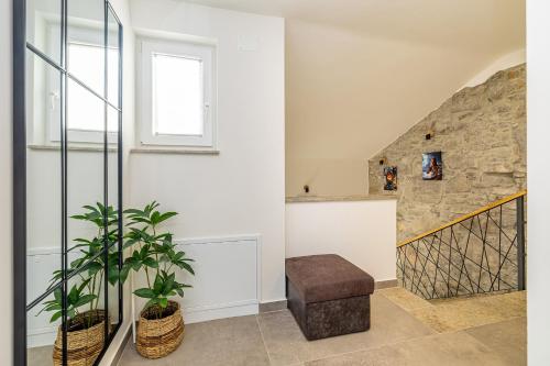 a living room with a stone wall and a stair case at Kuća za odmor ANTICA in Lakmartin