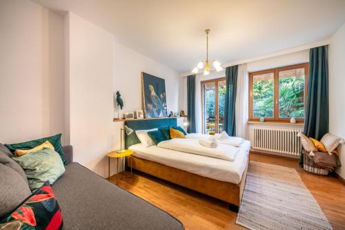 a bedroom with a bed and a couch at Reihenvilla Ambachgasse in Caldaro