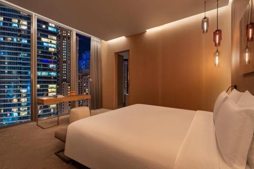 a bedroom with a white bed and a large window at Rixos Premium Dubai JBR in Dubai