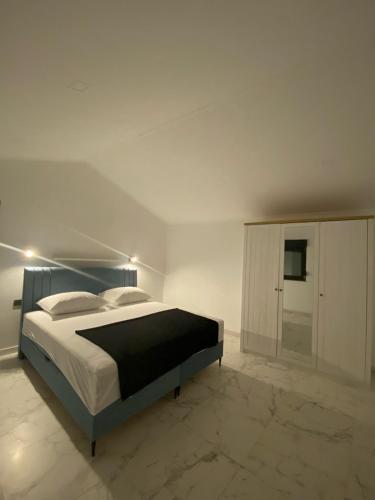a white bedroom with a bed and a cabinet at Luxury Apartman Anđela in Banjol