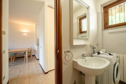 Oliveto LarioにあるCasa Onno con Vista Lago by Wonderful Italyの洗面台と鏡のある白いバスルーム