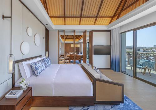 a bedroom with a large bed and a balcony at Anantara Mina Ras Al Khaimah Resort in Ras al Khaimah