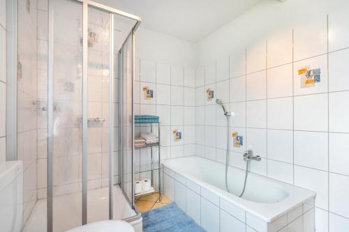 a white bathroom with a tub and a shower at Ferienhof Martens in Schülperweide