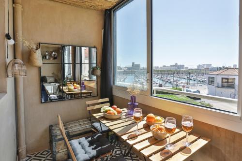 - une table avec des verres à vin dans une chambre avec une fenêtre dans l'établissement La petite escapade - Cosy - Vue Port, à Les Sables-dʼOlonne