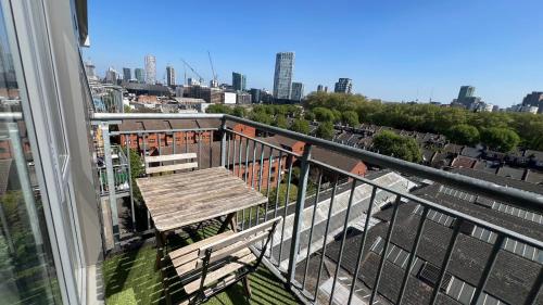 a balcony with a wooden table and a view of a city at Sunset Heights Bright 2BR with City Views and Free Parking in London