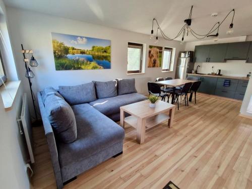 a living room with a blue couch and a table at Highland Warmia - Gospodarstwo agroturystyczne in Jeziorany