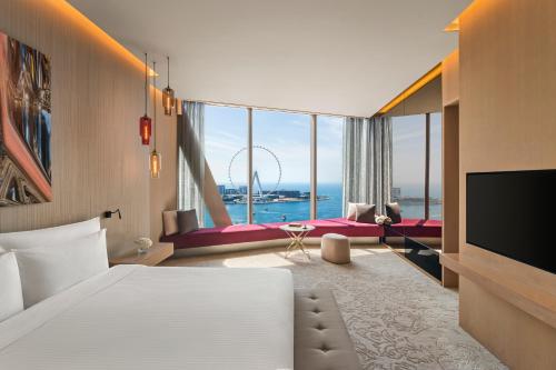 a hotel room with a bed and a large window at Rixos Premium Dubai JBR in Dubai