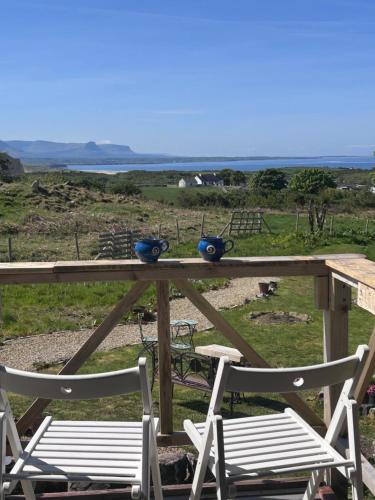 a picnic table with two chairs and two blue bowls on it at The Creevy Cabin in Ballure