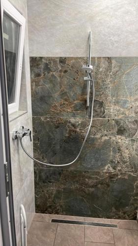a shower with a hose attached to a stone wall at Residence at lake Balaton in Siófok