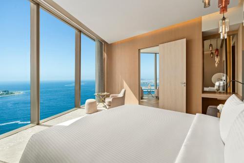 a bedroom with a large white bed and large windows at Rixos Premium Dubai JBR in Dubai