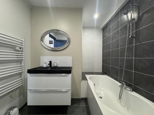 a bathroom with a sink and a tub and a mirror at Le Saint Victeur - 8pers - Babyfoot - Rêve au Mans in Le Mans